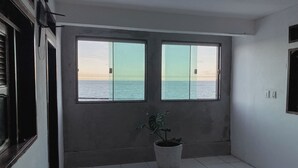 A room with two large windows offering a view of the sea. - Hotel 5 Sóis (Olinda)