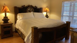 A wooden four-poster bed with white linens, two bedside lamps, and a window with blinds. - Cabin A at Casa Blanca, 1BR/1BA, Sleeps 4, Porch, Grill (Ingram)