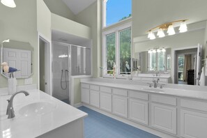 A modern bathroom with a large vanity, dual sinks, and a walk-in shower. - Tabby on the Tee - Four Bedroom House, Sleeps 15 (Fripp Island)