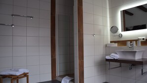 A modern bathroom with a shower, a sink, and a mirror. - Weingut Manuel Sauer (Nordheim a. Main)
