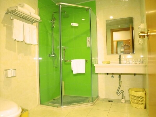 A bathroom with a green shower enclosure, a white sink with a mirror above it, and a yellow trash bin. - Greentree Inn Beijing Fangshan District Jingzhou Road Magezhuang Subway Station Express Hotel (Fangshan)