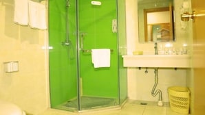 A bathroom with a green shower enclosure, a white sink with a mirror above it, and a yellow basket. - Greentree Inn Beijing Fangshan District Jingzhou Road Magezhuang Subway Station Express Hotel (Fangshan)