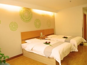 Habitación de hotel con dos camas, cabecero de madera y pared con diseños circulares.
