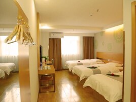 Una habitación de hotel con dos camas, un escritorio y un aire acondicionado.
