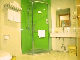 Un baño con ducha de vidrio, un lavabo blanco y un espejo encima.