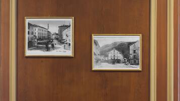 Due fotografie in bianco e nero incorniciate raffiguranti scorci di strada, appese a un muro di legno.