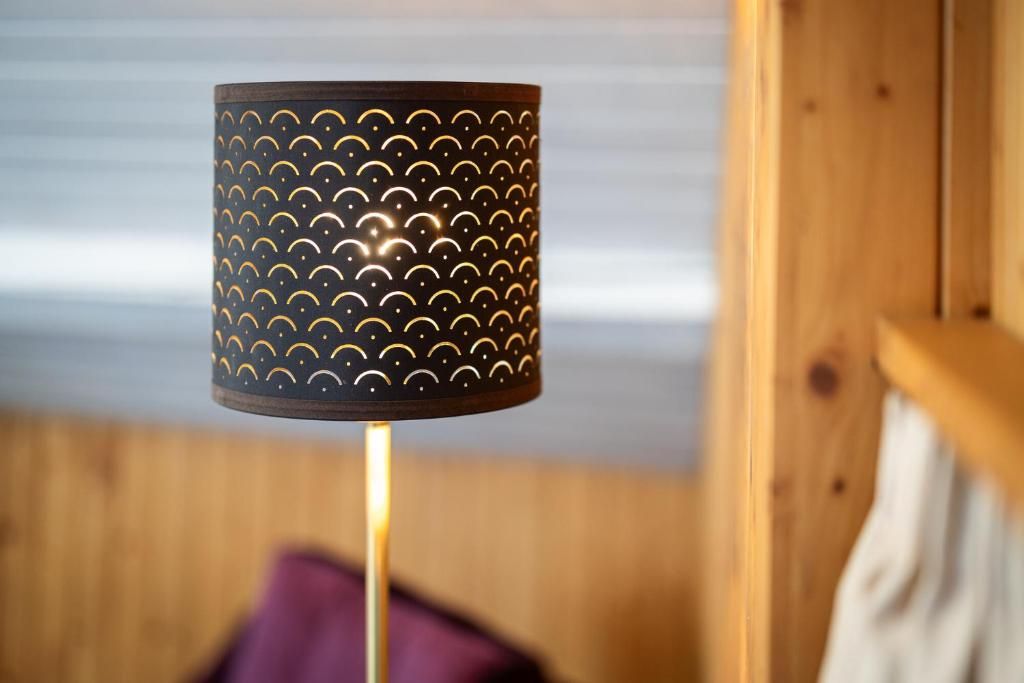 A cylindrical lamp with a patterned design on a wooden surface.