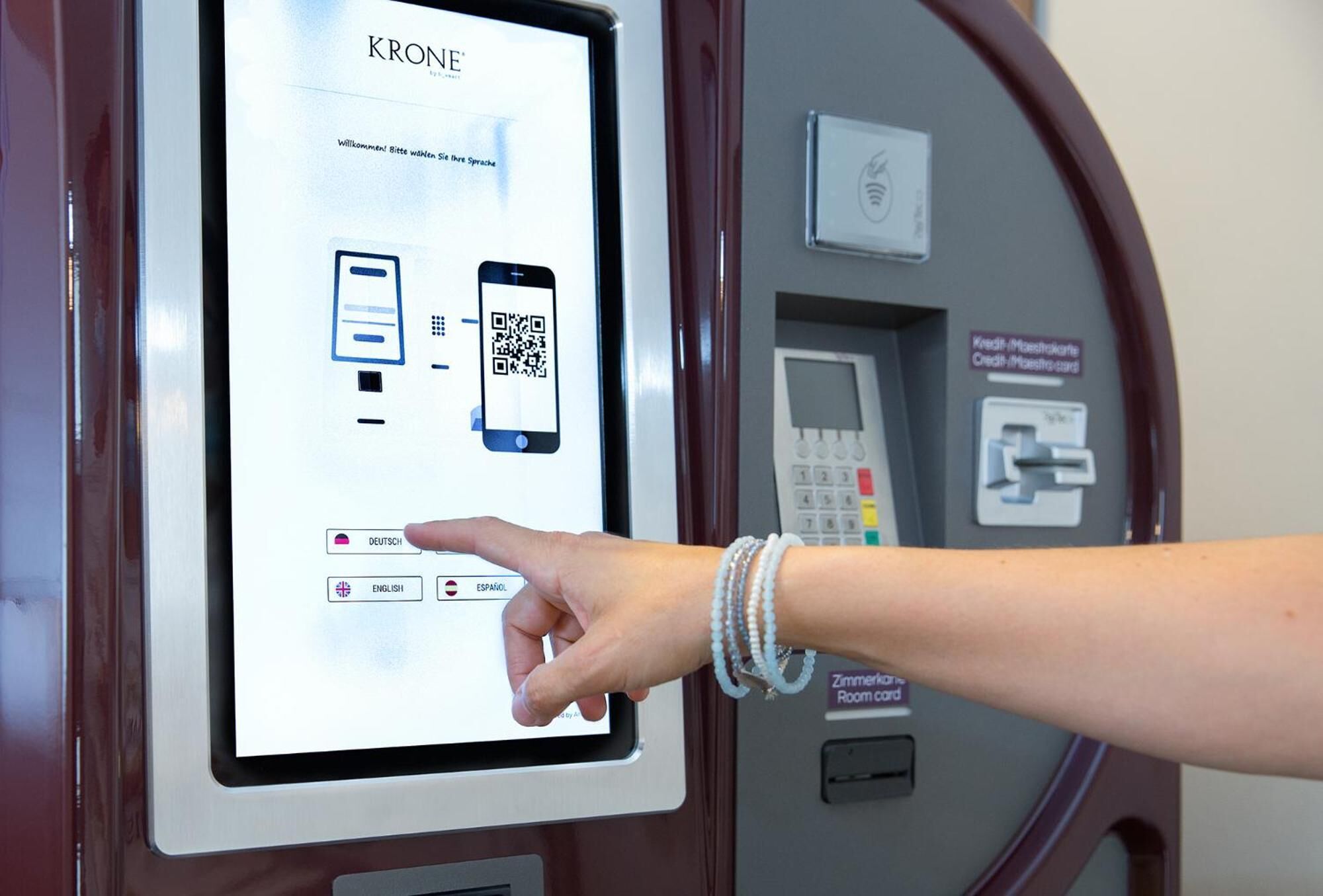 Un quiosco digital con un código QR y opciones para seleccionar idioma.