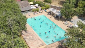 An aerial view of a swimming pool surrounded by trees and shaded areas with lounge chairs. - Domaine des Chênes Blancs - Camping (Saint-Saturnin-les-Apt)