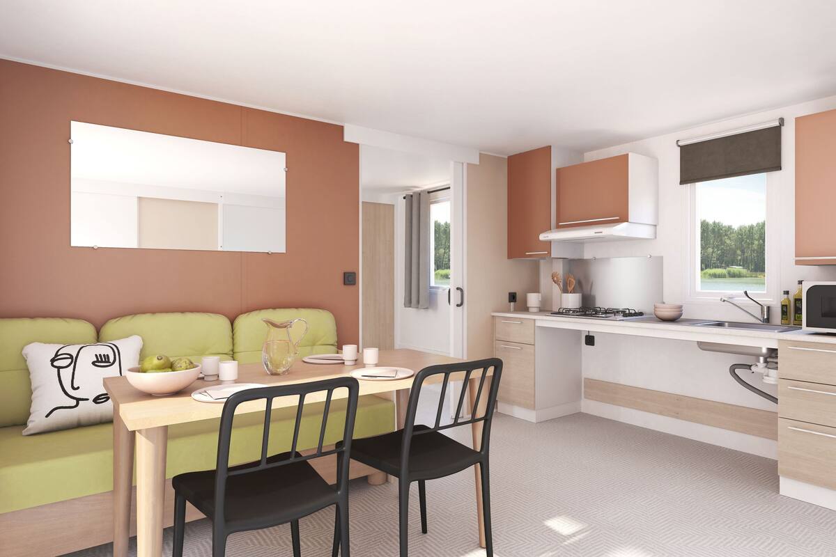 Une cuisine moderne avec un coin repas, comprenant un canapé vert, une table en bois et des chaises noires.
