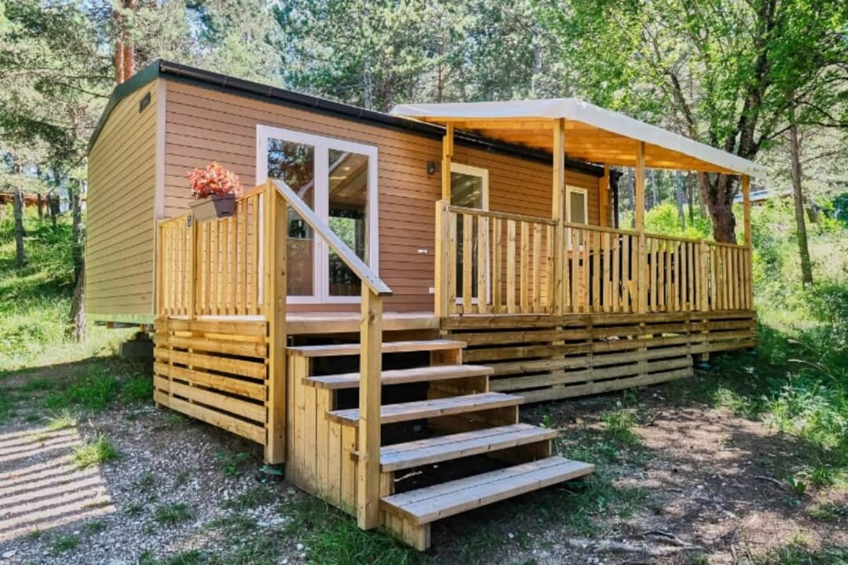 Eine Holzhütte mit Veranda und Stufen zum Eingang.