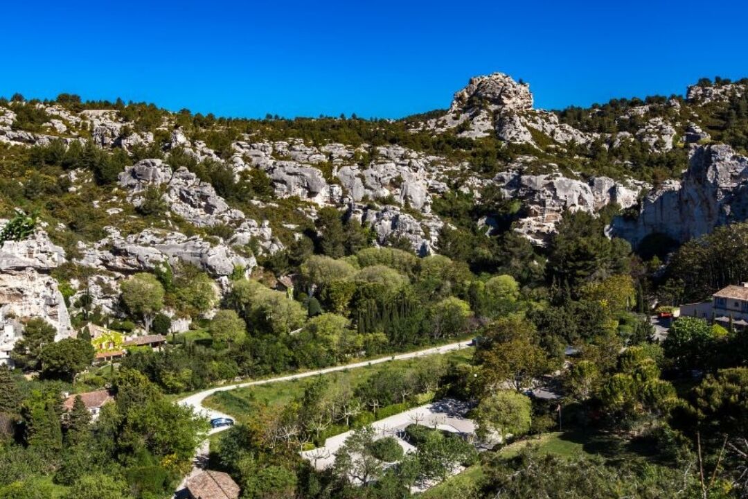 Eine gebirgige Landschaft mit felsigem Gelände, vereinzelten Bäumen und einem gewundenen Pfad.