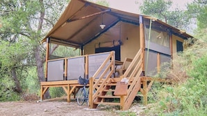 Uma cabana de madeira com varanda coberta e uma bicicleta estacionada na frente.