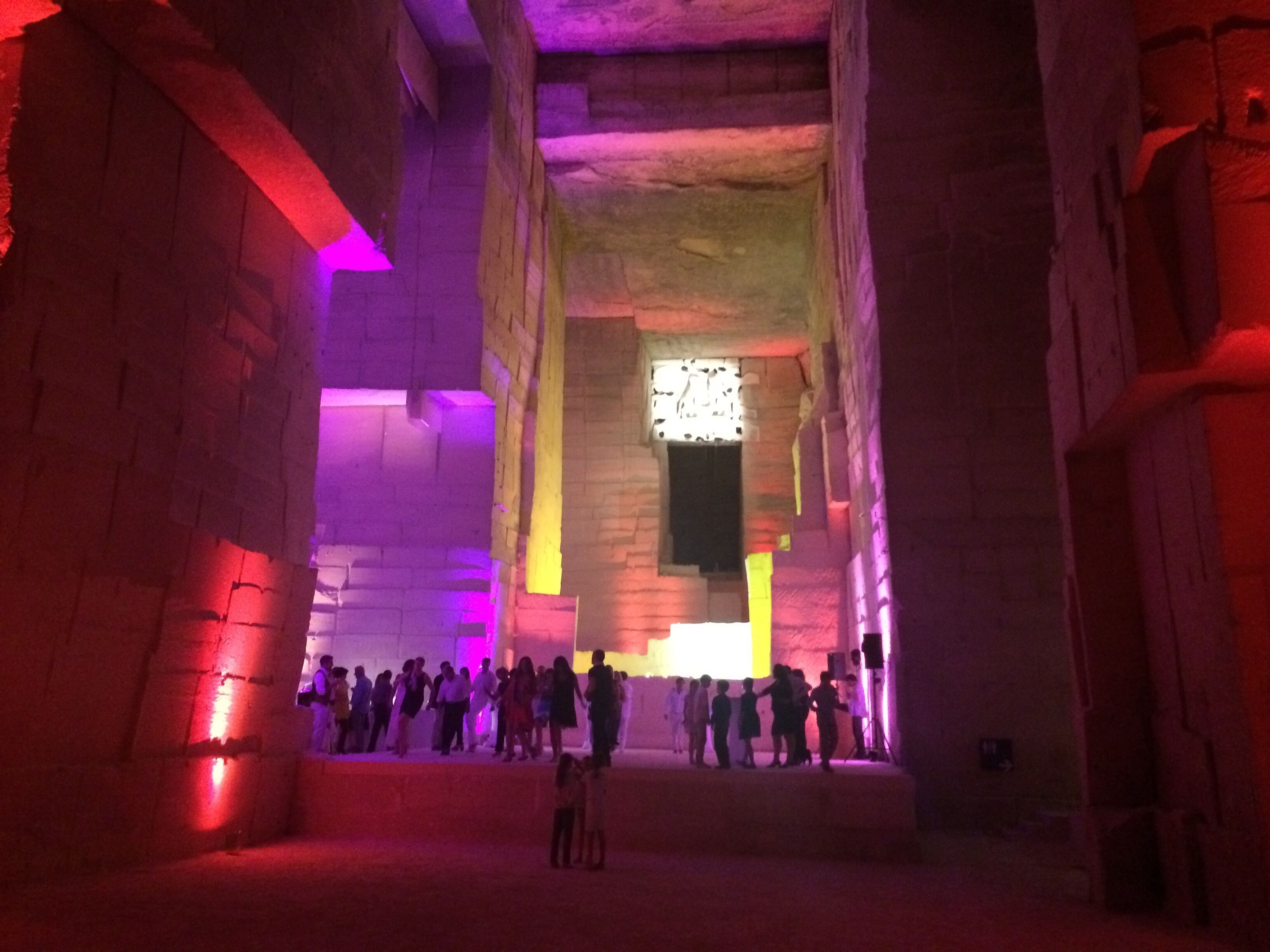 A large, dimly lit interior space with stone walls and a central open area.