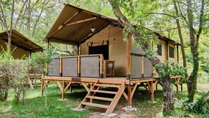 Una cabaña de madera con un porche cubierto y una escalera que lleva a la entrada.