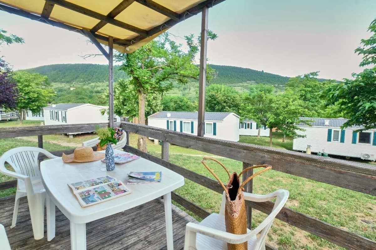 Un área de estar al aire libre con techo, que incluye una mesa, sillas y un jarrón decorativo.