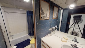 Une salle de bain avec une baignoire, des toilettes, un lavabo et un miroir.