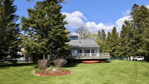 Ein Haus mit großem Rasen, einer Terrasse und einer Garage.