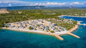 An aerial view of a coastal resort with multiple buildings, a beach, and clear blue waters. - Buqez - 2BR - Beach Villa 42 (Pakostane)