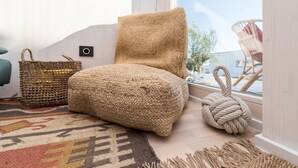 A cozy room with a woven chair, a woven pouf, and a woven pouf on a windowsill. - Buqez - 2BR - Beach Villa 42 (Pakostane)