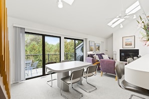 Relax in a spacious living area with a dining table, comfortable seating, and a fireplace.