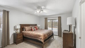 A bedroom with a bed, nightstands, a ceiling fan, and a window with curtains. - Trout Creek #122 SHUTTLE TO NUBS! POOLS &Fitness! (Harbor Springs)