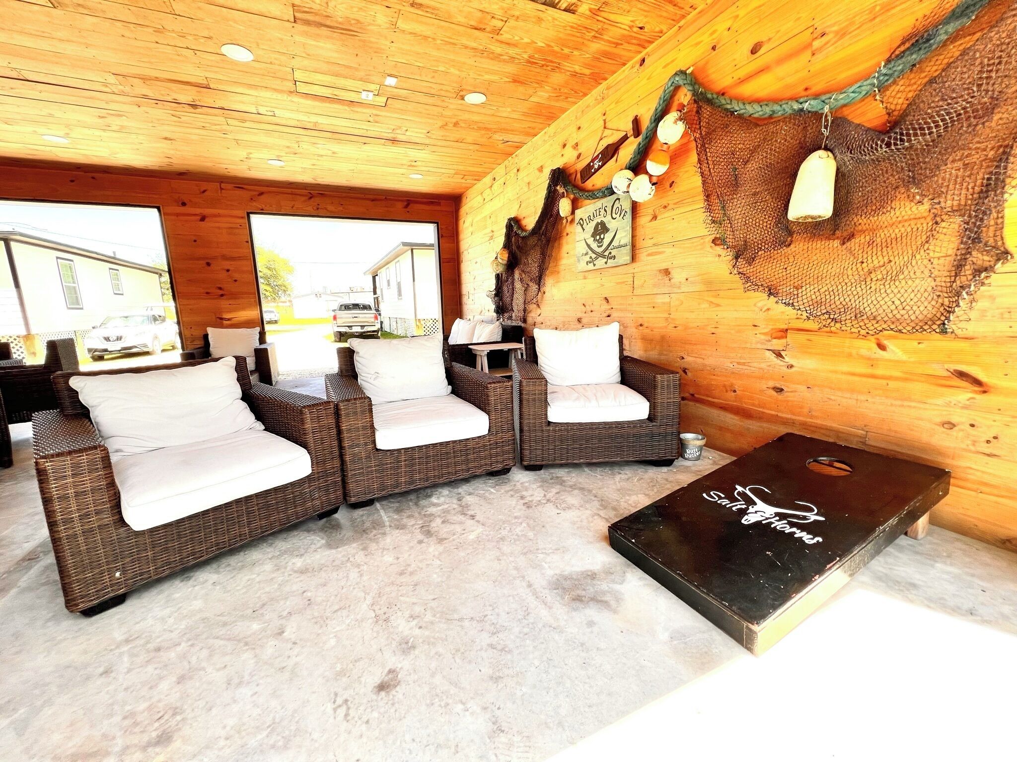 Un interior de madera acogedor con sofás de mimbre y una mesa de billar.