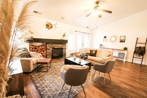 A cozy living room with a fireplace, a sofa, two armchairs, and a coffee table. - New Listing! Prime Location, Southwestern Modern! (Flagstaff)