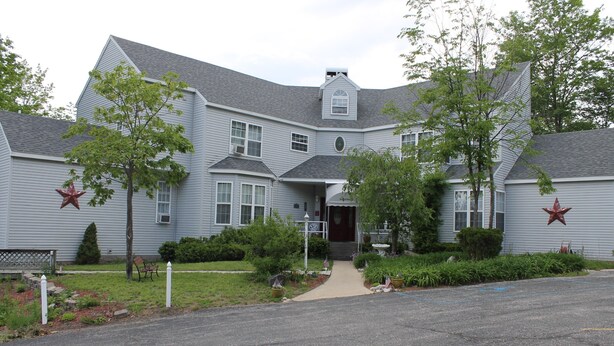 A two-story house with a front porch, a garage, and a driveway.