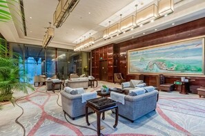 Un hall d’entrée spacieux, agrémenté d’un grand tableau, de sièges confortables et d’un design moderne.