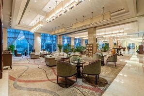 A spacious lobby with modern furniture, large windows, and a well-lit ceiling. - Jinyue International Hotel Jinjiang (Jingjiang)