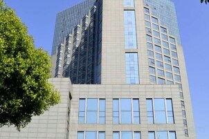 A tall building with a modern design, featuring a mix of glass and concrete facades.