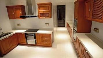 A modern kitchen with wooden cabinets, a built-in oven, and a stainless steel range hood.