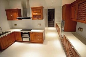 Une cuisine moderne avec des meubles en bois, un four encastré et une hotte de cuisine en acier inoxydable.