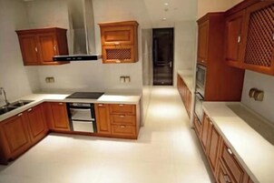 Una cocina moderna con armarios de madera, horno empotrado y campana extractora de acero inoxidable.