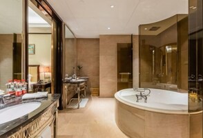 Un baño lujoso con una bañera grande, dos lavamanos y un espejo amplio.