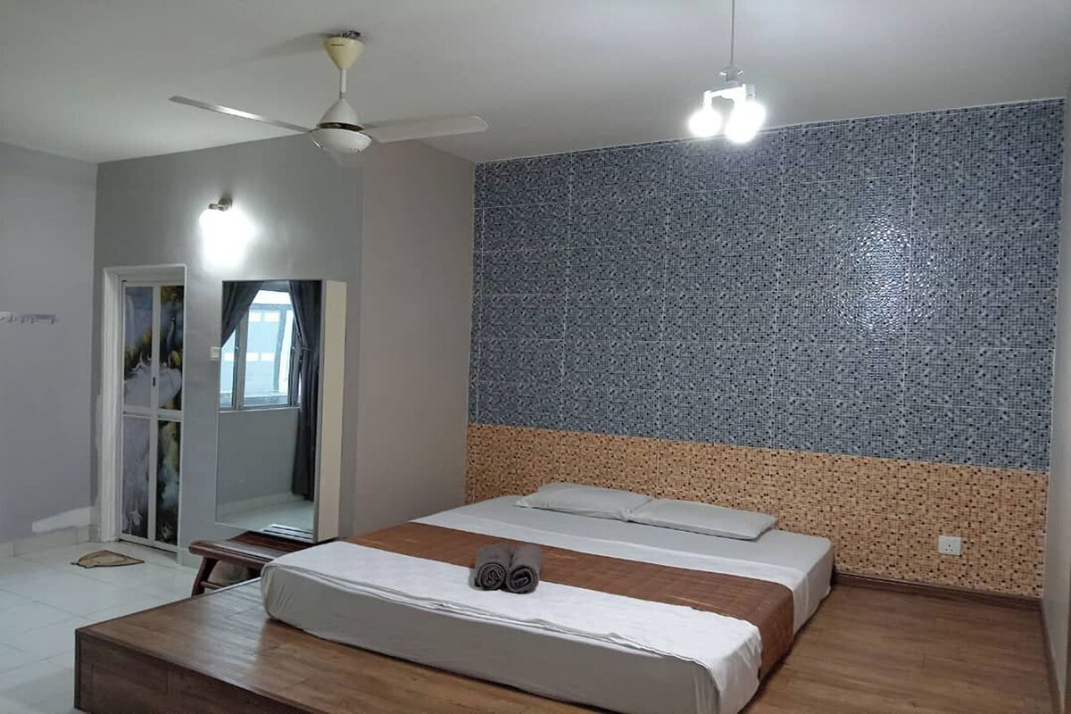 Ein Schlafzimmer mit Bett, Deckenventilator und einer Wand mit strukturierter Oberfläche.