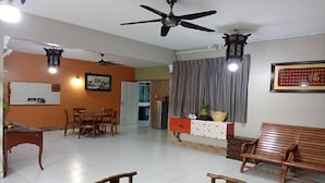 Amplia sala de estar con una mesa de comedor, sillas, un sofá y un ventilador de techo.