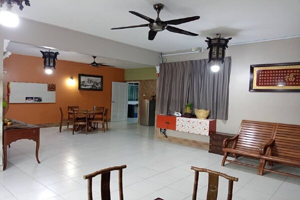A spacious living area with a dining table, chairs, a sofa, and a ceiling fan. - Aeon Tebrau Apartment Johor Bahru (Johor Bahru)