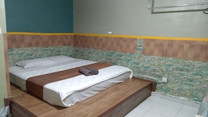 A double bed with a wooden headboard, a small bedside table, and a wall-mounted TV. - Aeon Tebrau Apartment Johor Bahru (Johor Bahru)