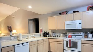A modern kitchen with white appliances, wooden cabinets, and a tiled backsplash. - Renovated WATERSLIDE private Heated pool with Spa Golf Course on-call service  (Mesa)