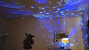 A room with a ceiling projection of blue patterns, a mirror, and a small table with a lamp. - Renovated WATERSLIDE private Heated pool with Spa Golf Course on-call service  (Mesa)