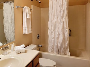 A bathroom with a bathtub, toilet, sink, and a mirror. - Renovated WATERSLIDE private Heated pool with Spa Golf Course on-call service  (Mesa)