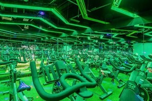 A gym with multiple exercise machines arranged in rows.