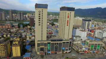 A cityscape with two prominent high-rise buildings, one with a vertical sign and the other with a horizontal sign.