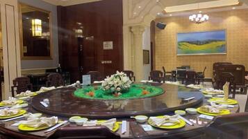 A conference room with a round table, chairs, and a floral centerpiece.