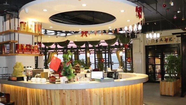 A reception desk with a circular wooden design, a large window with curtains, and a sign with Chinese characters. - Greentree Inn Zhangjiakou Xuanhua Boju Business Hotel (Zhangjiakou)