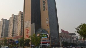 A tall building with multiple floors, featuring a prominent sign with Chinese characters. - Greentree Inn Zhangjiakou Xuanhua Boju Business Hotel (Zhangjiakou)