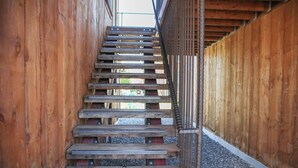 Un escalier en bois avec des rampes en métal, menant à un niveau supérieur.