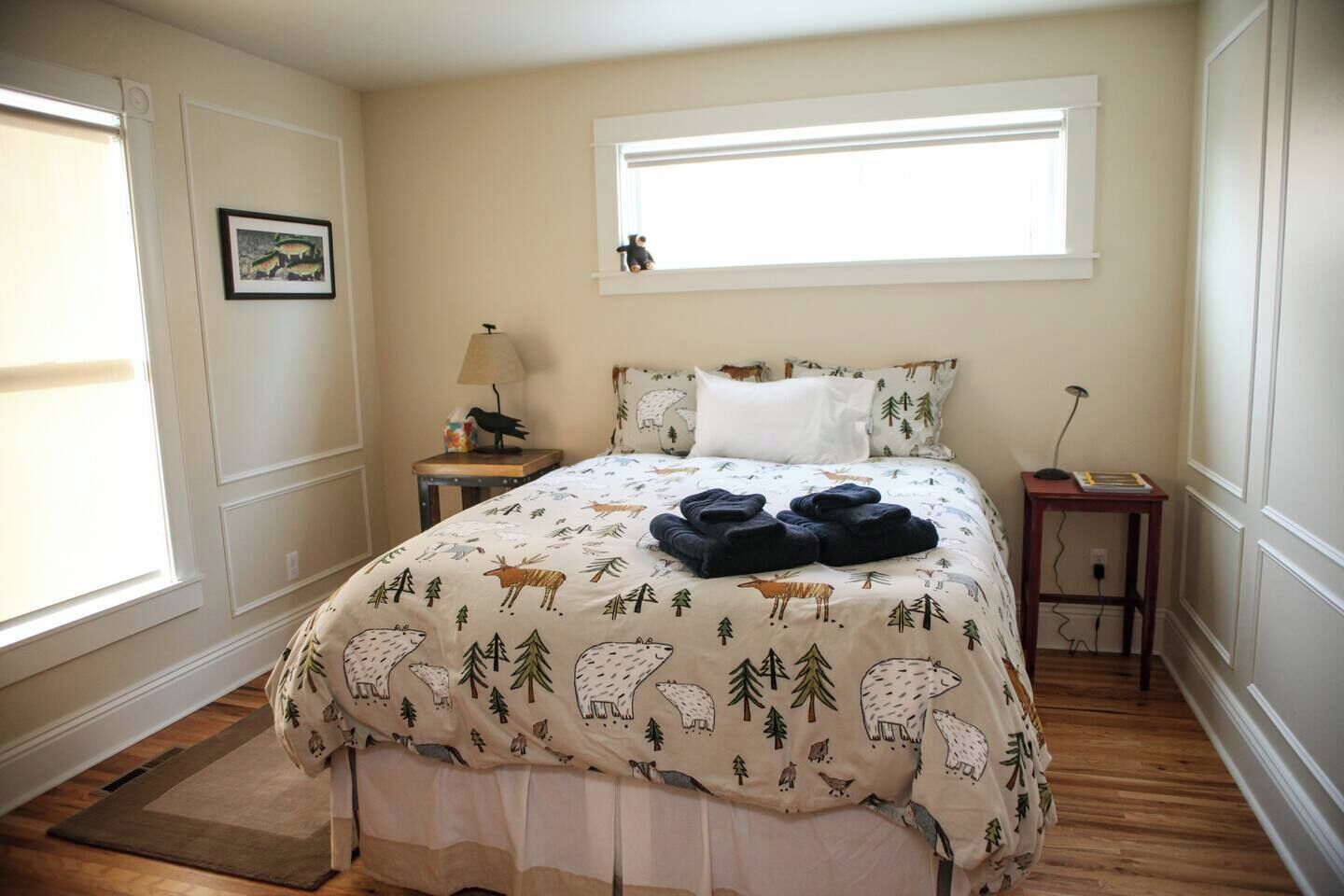 Une chambre à coucher avec un lit, une fenêtre, une table de chevet et une lampe.
